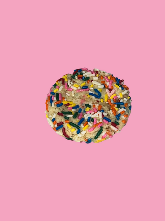 Cookie with colorful sprinkles on a pink background